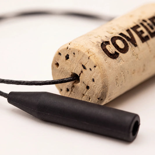A close-up of a sunglass retainer product, close up of silicone attachement with a cork segment printed with the COVELiFE logo.