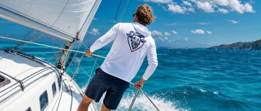 Man sailing in a white COVELiFE SolarTech UPF hoodie with the Scout logo on the back.