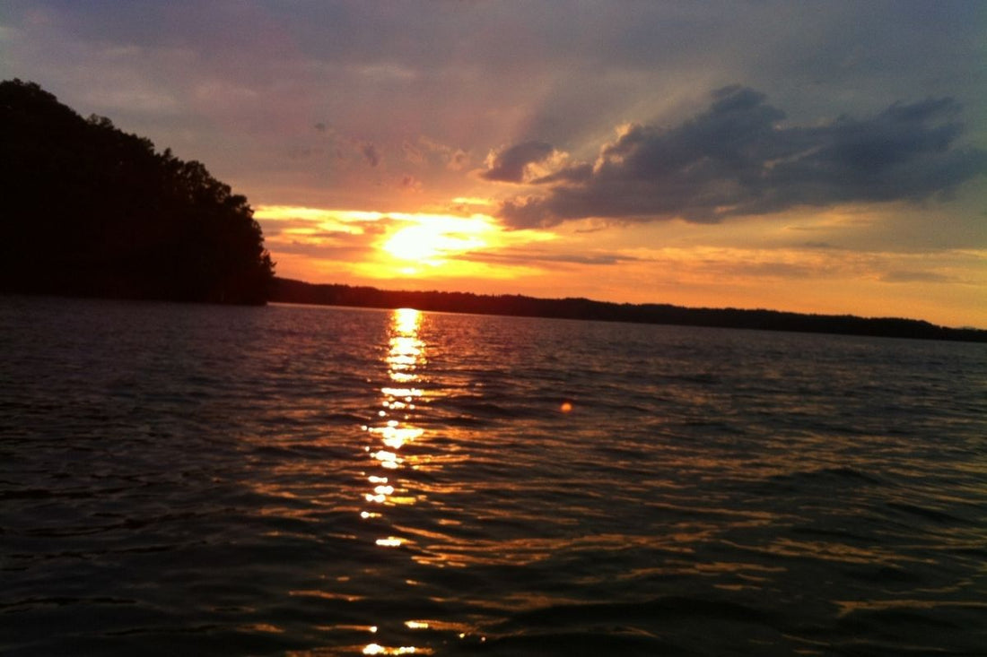 Sunset over the lake with golden light reflecting across the water.