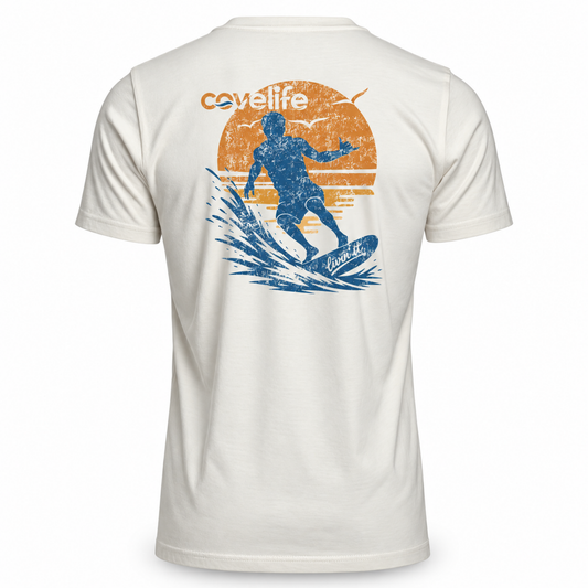 A cream short-sleeve t-shirt shown from the back, featuring a distressed graphic of a surfer riding a wave in blue, with an orange sun and the word 'covellite' printed above.
