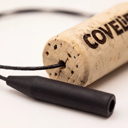 A close-up of a sunglass retainer product, close up of silicone attachement with a cork segment printed with the COVELiFE logo.