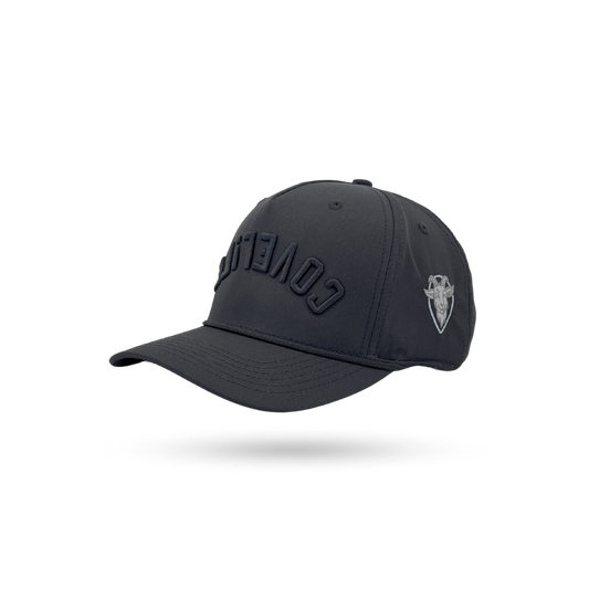 A dark charcoal gray baseball cap with 'COVERT' embroidered in tonal black on the front and a small silver shield logo on the side, shown on a white background with a soft shadow.