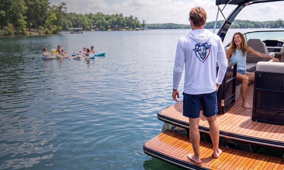 Man wearing a white COVELiFE UPF hoodie on a boat at the lake